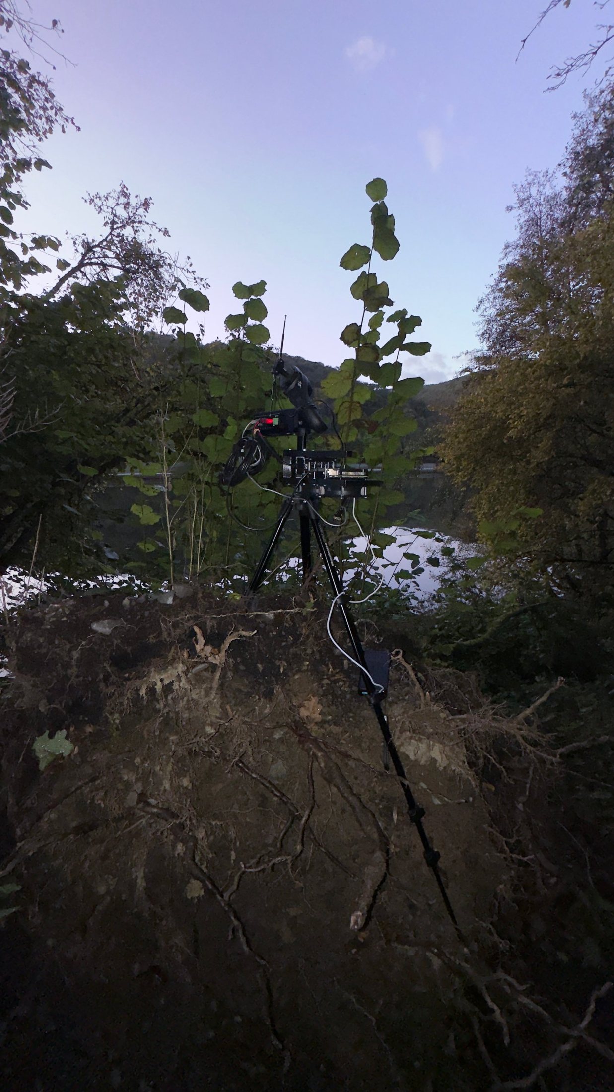 Radio recording kit on a tripod by a river at dusk