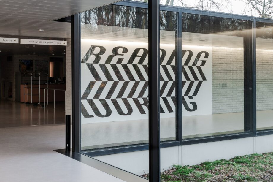 Large lettering mural seen through a glass facade
